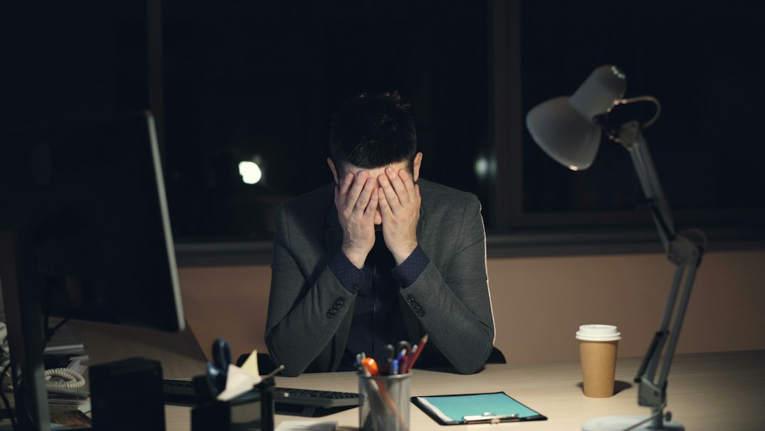 Business owner working late at a computer under financial pressure